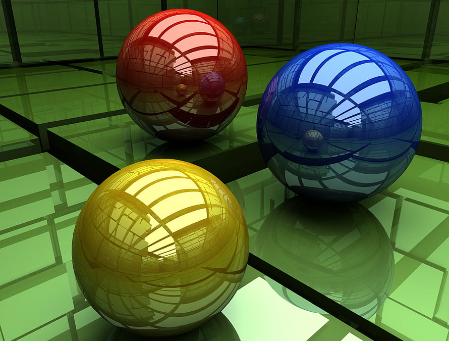 Three glossy red blue and yellow spheres reflecting a green grid environment in a 3D render HD wallpaper