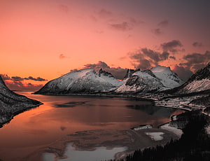 Snow-Capped Mountains Reflected in a Lake Under a Vibrant Pink and Orange Sunset Sky HD wallpaper