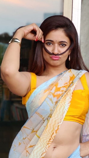 Poonam Bajwa in a yellow blouse and light blue sari with a playful pose HD phone wallpaper