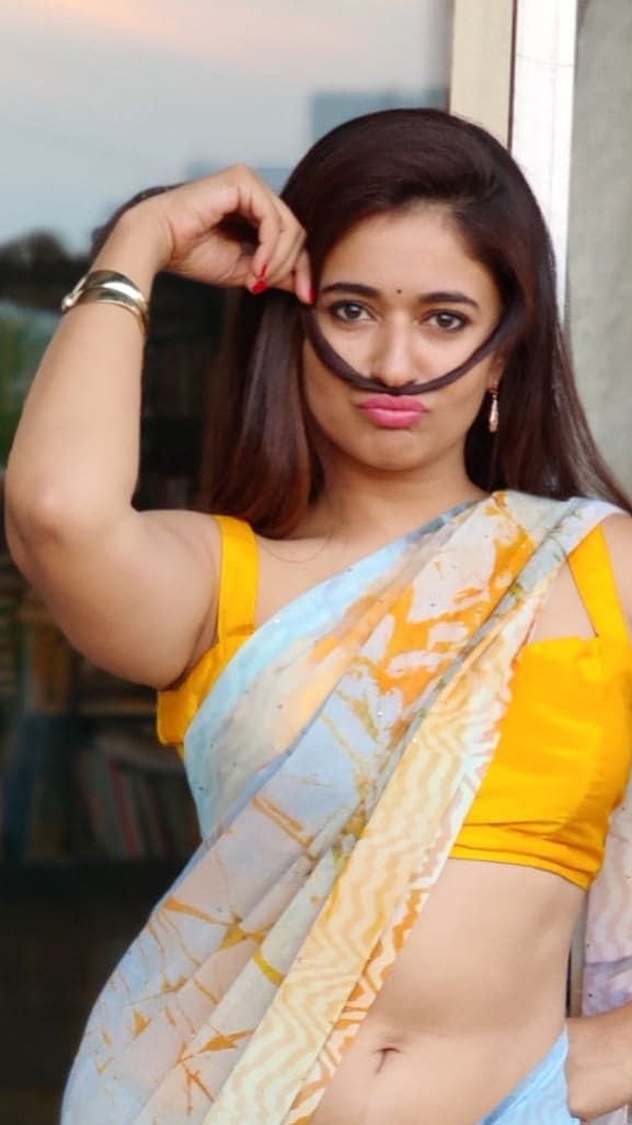 Poonam Bajwa in a yellow blouse and light blue sari with a playful pose HD phone wallpaper