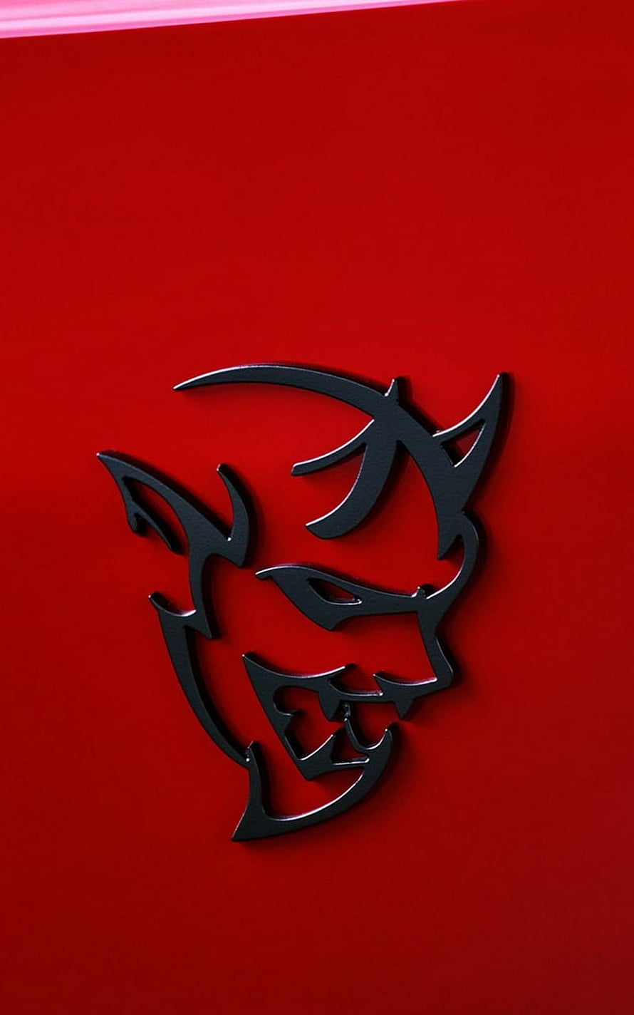Dodge Hellcat Demon Logo Emblem on Glossy Red Automotive Surface HD phone wallpaper