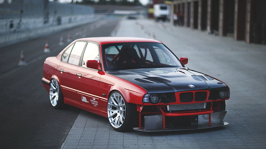 Red BMW E34 M5 Race Car with Black Hood and Front Splitter on Track HD wallpaper