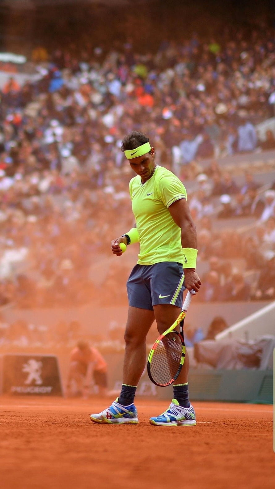 Rafael Nadal on the red clay court at Roland Garros in a neon yellow Nike kit HD phone wallpaper