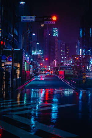 Neon-lit Tokyo street at night with wet pavement reflecting vibrant city lights HD phone wallpaper