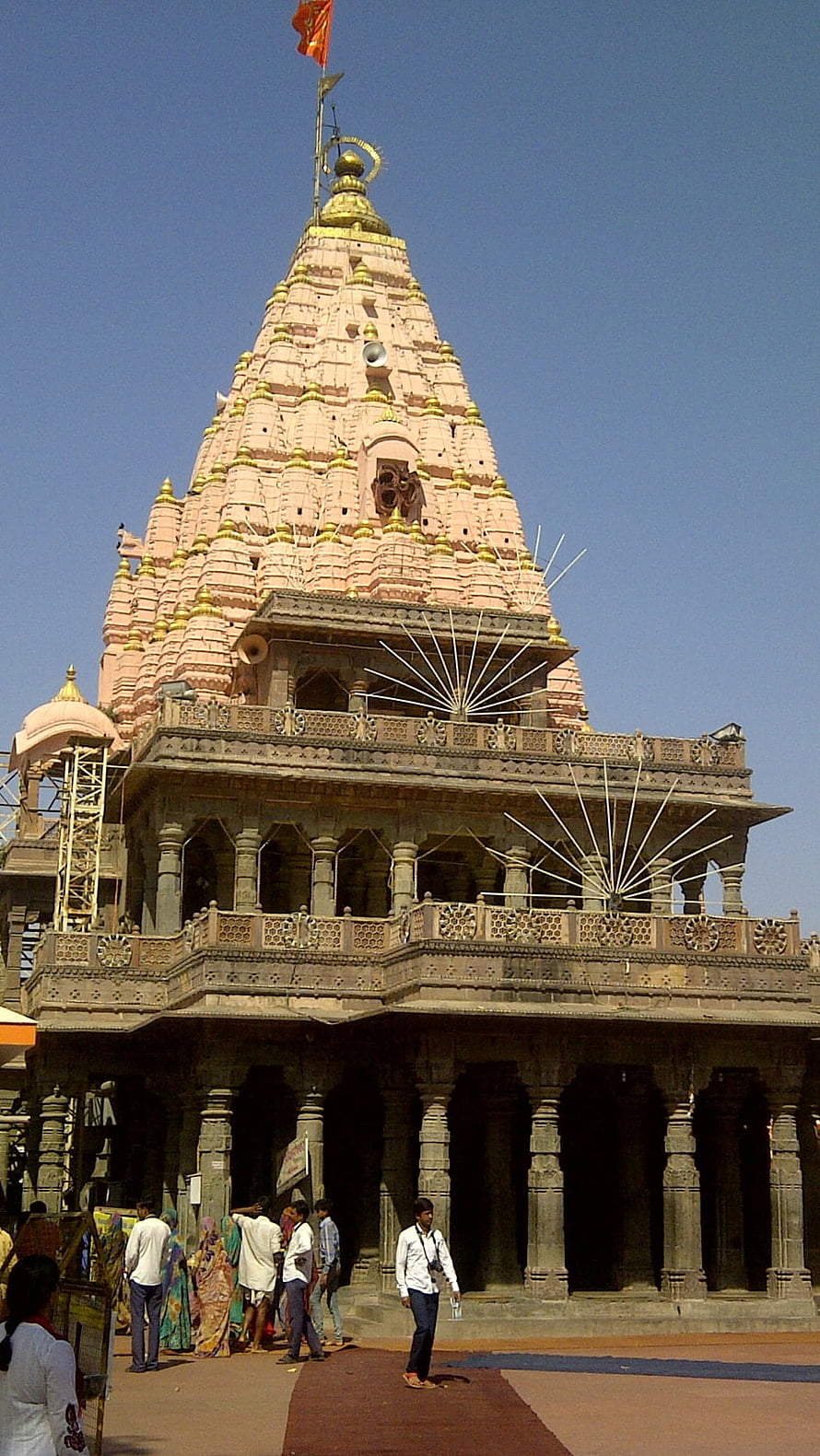Mahakaleshwar Temple in Ujjain with ornate shikhara spire and stone colonnade under a clear blue sky HD phone wallpaper