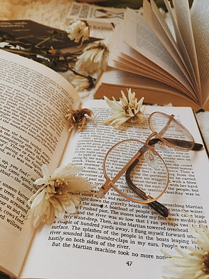 Vintage Reading Nook with Open Book, Round Glasses, and Dried Flowers HD phone wallpaper