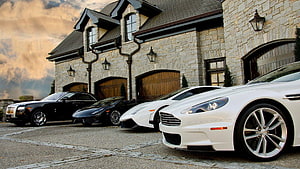 Luxury Supercars Parked in Front of a Grand Stone Mansion at Dusk HD wallpaper