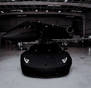 Matte Black Lamborghini Aventador Parked in Hangar with Private Jet HD wallpaper
