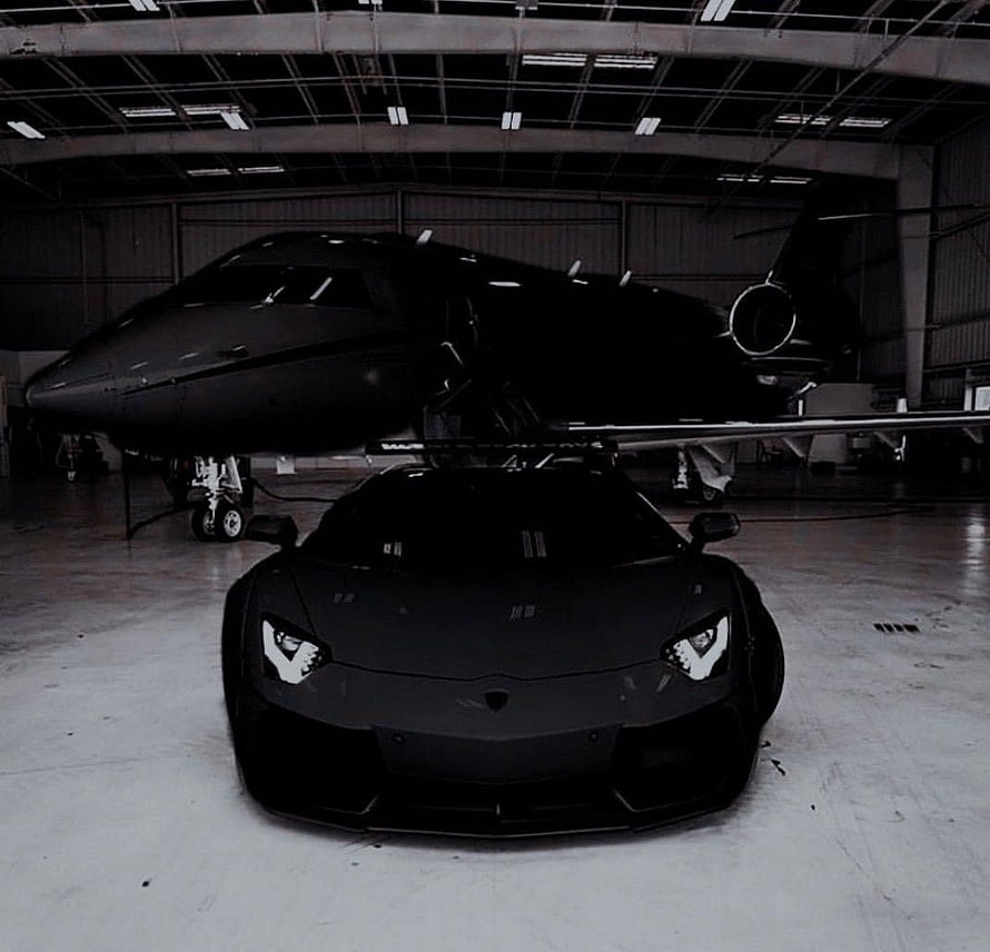 Matte Black Lamborghini Aventador Parked in Hangar with Private Jet HD wallpaper