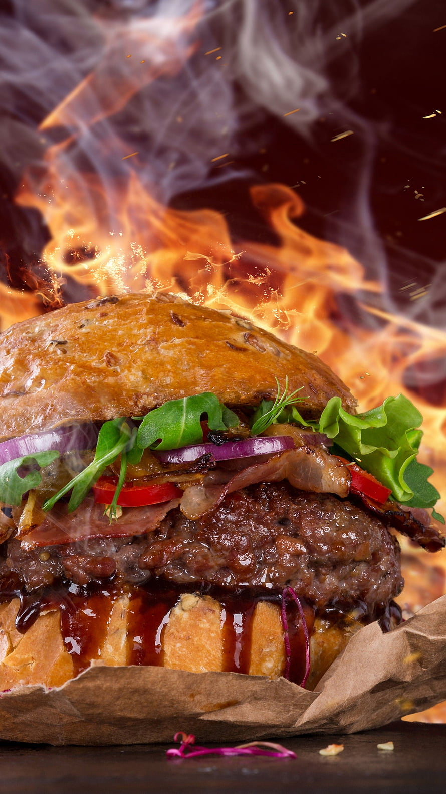 Flaming Gourmet Burger With Crispy Bacon, Fresh Greens, and Melted Cheese on a Dark Background HD phone wallpaper