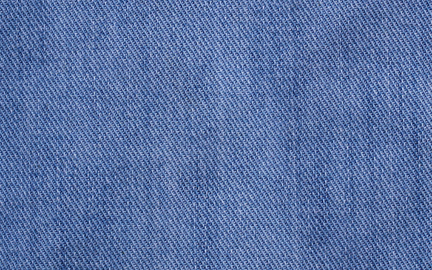 Close-up of blue denim fabric weave showing detailed twill texture and thread pattern HD wallpaper