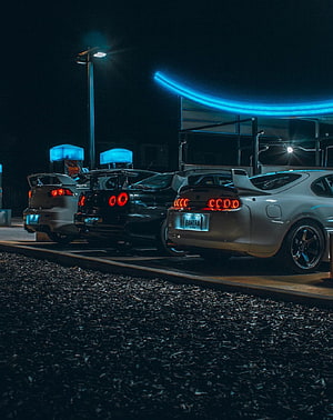 Nighttime JDM Supra and R34 GT-R lineup with glowing taillights and neon accents HD phone wallpaper