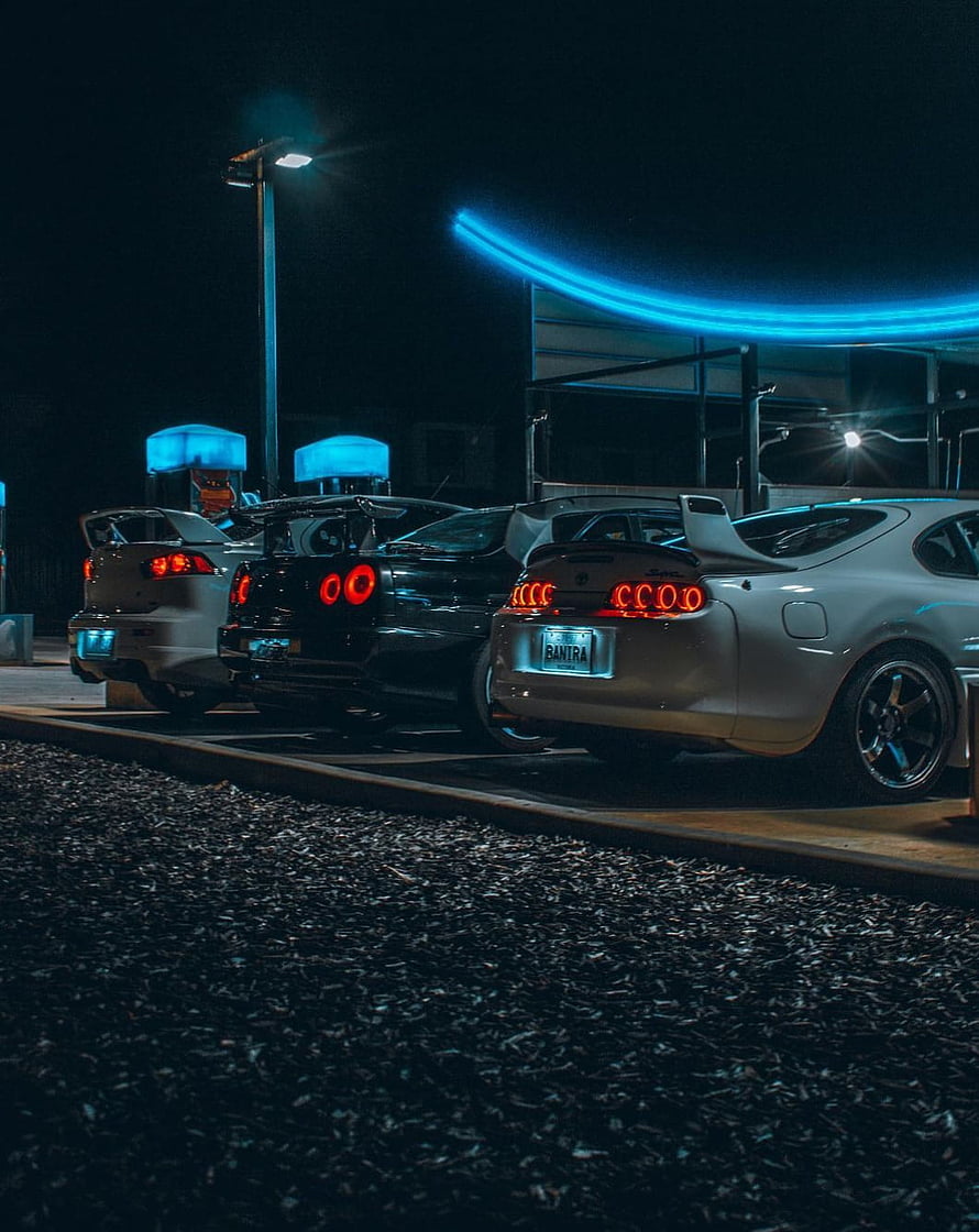 Nighttime JDM Supra and R34 GT-R lineup with glowing taillights and neon accents HD phone wallpaper
