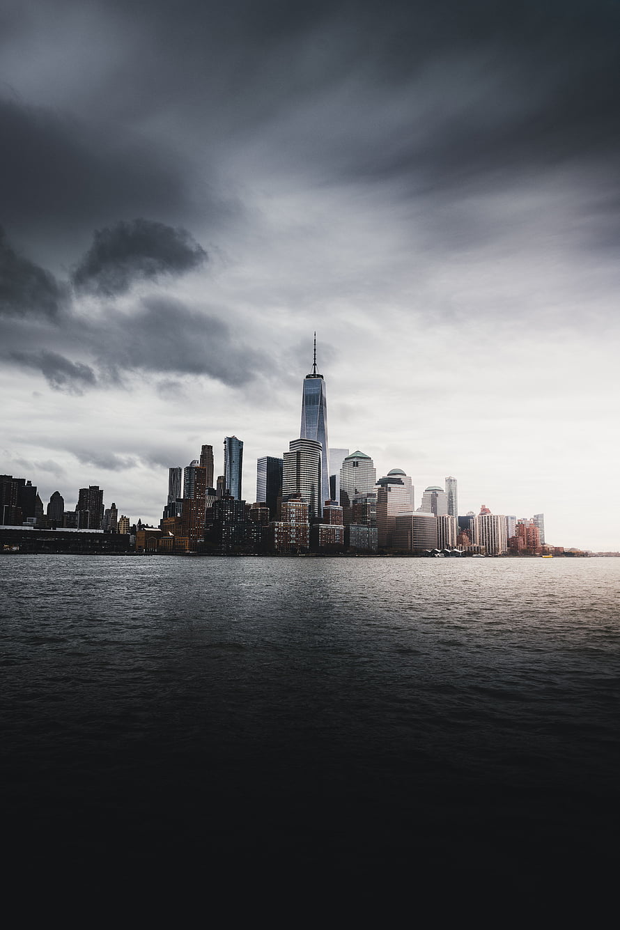 Dramatic New York City Skyline with One World Trade Center Under Stormy Clouds HD phone wallpaper