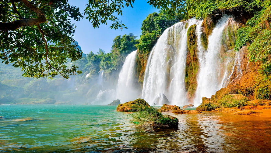 Majestic Detian Waterfall Cascading into Turquoise Pool Surrounded by Lush Green Jungle HD wallpaper