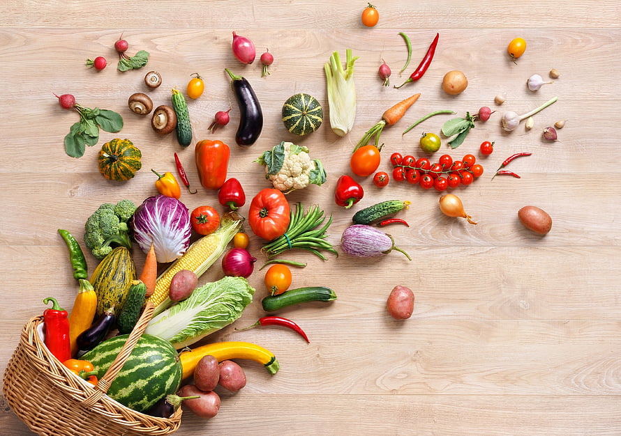 Fresh Organic Vegetables Spilling From Wicker Basket On Wooden Table HD wallpaper