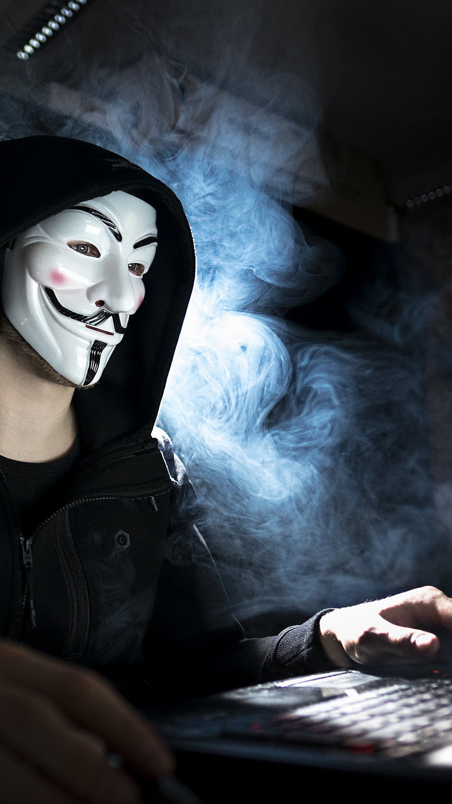 Anonymous Guy Fawkes Mask Hacker Typing on Laptop in Dramatic Blue Smoke HD phone wallpaper