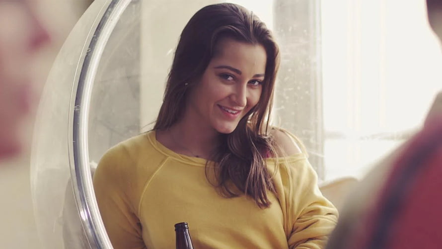 Dani Daniels in a yellow off-shoulder sweater smiling in a bright indoor setting HD wallpaper