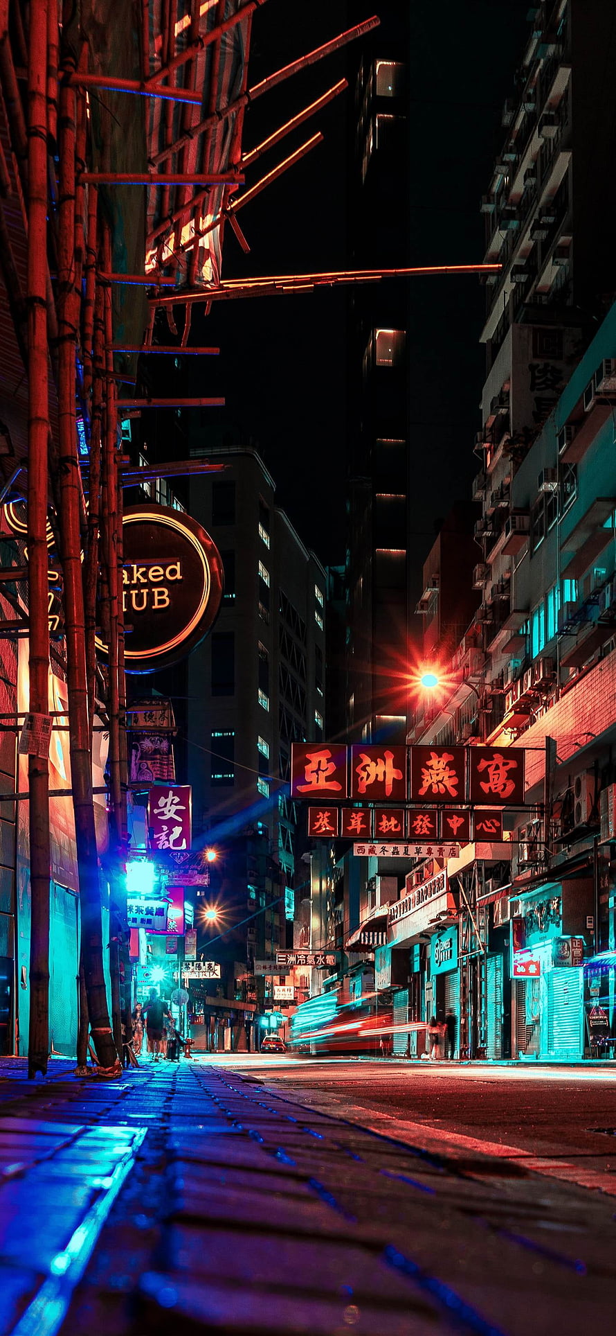 Neon-lit Hong Kong street at night with bamboo scaffolding and glowing signs HD phone wallpaper