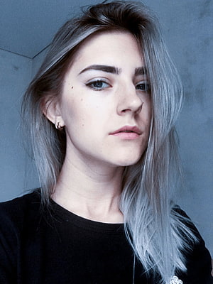 Eva Elfie Portrait with Silver Hair and Black Top Against a Cool Toned Wall HD phone wallpaper
