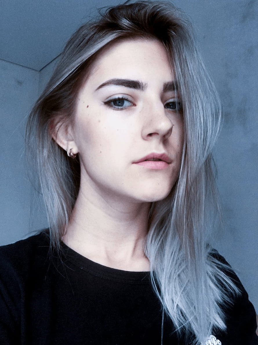 Eva Elfie Portrait with Silver Hair and Black Top Against a Cool Toned Wall HD phone wallpaper