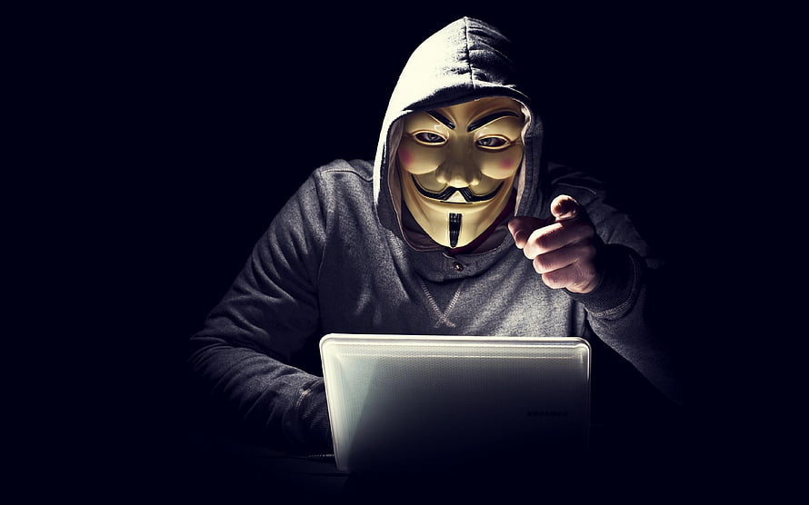 Anonymous Hacker Wearing Guy Fawkes Mask Pointing at Laptop Screen in Dark Room HD wallpaper