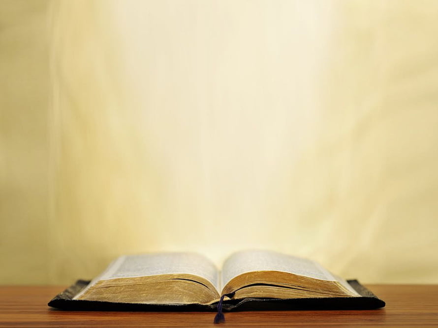 Open Holy Bible on Wooden Table with Soft Warm Lighting and Vintage Aesthetic HD wallpaper