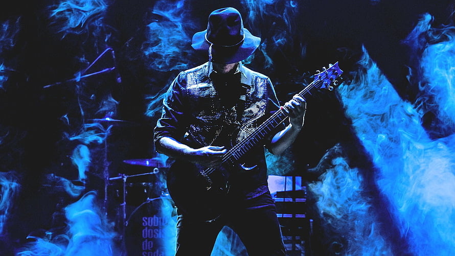 Musician Playing Electric Guitar On Stage With Blue Smoke And Hat HD wallpaper