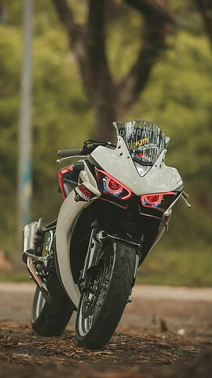 White Yamaha R15 Sport Motorcycle with Red LED Headlights Parked on a Forest Path HD phone wallpaper