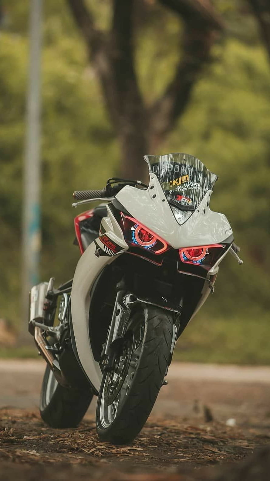White Yamaha R15 Sport Motorcycle with Red LED Headlights Parked on a Forest Path HD phone wallpaper