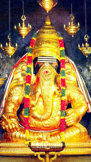 Golden Karpaga Vinayagar Statue Adorned With Flower Garlands And Hanging Oil Lamps HD phone wallpaper