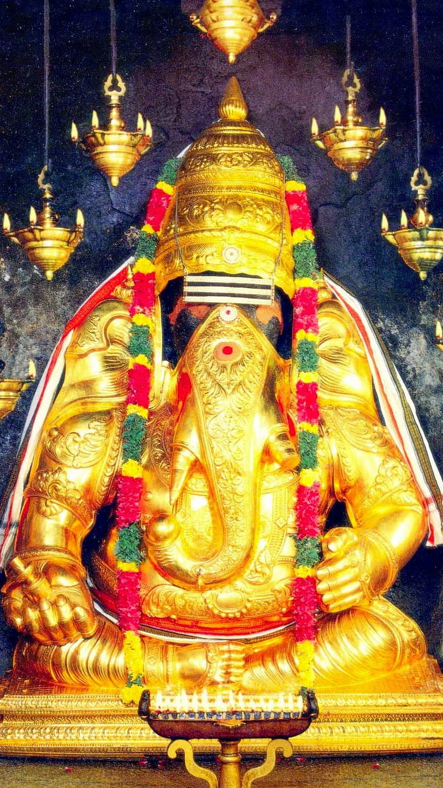 Golden Karpaga Vinayagar Statue Adorned With Flower Garlands And Hanging Oil Lamps HD phone wallpaper