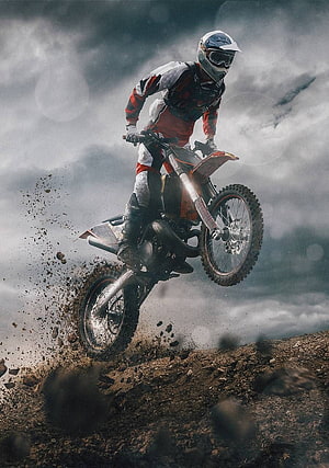 KTM Dirt Bike Rider Launching Off a Muddy Trail Under a Dramatic Stormy Sky HD phone wallpaper