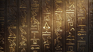 Ancient Egyptian Hieroglyphs Carved on Dark Stone Wall with Golden Accents HD wallpaper