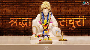Sai Baba Statue Seated in White Robes with Flower Garland and Oil Lamp on Brick Background HD wallpaper