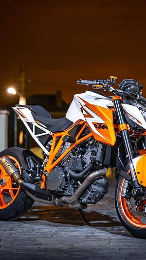 KTM Duke 390 Naked Motorcycle in Orange and White Parked on Cobblestone at Night HD phone wallpaper