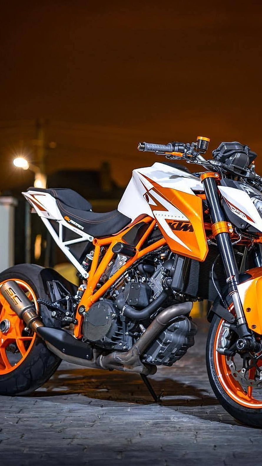 KTM Duke 390 Naked Motorcycle in Orange and White Parked on Cobblestone at Night HD phone wallpaper
