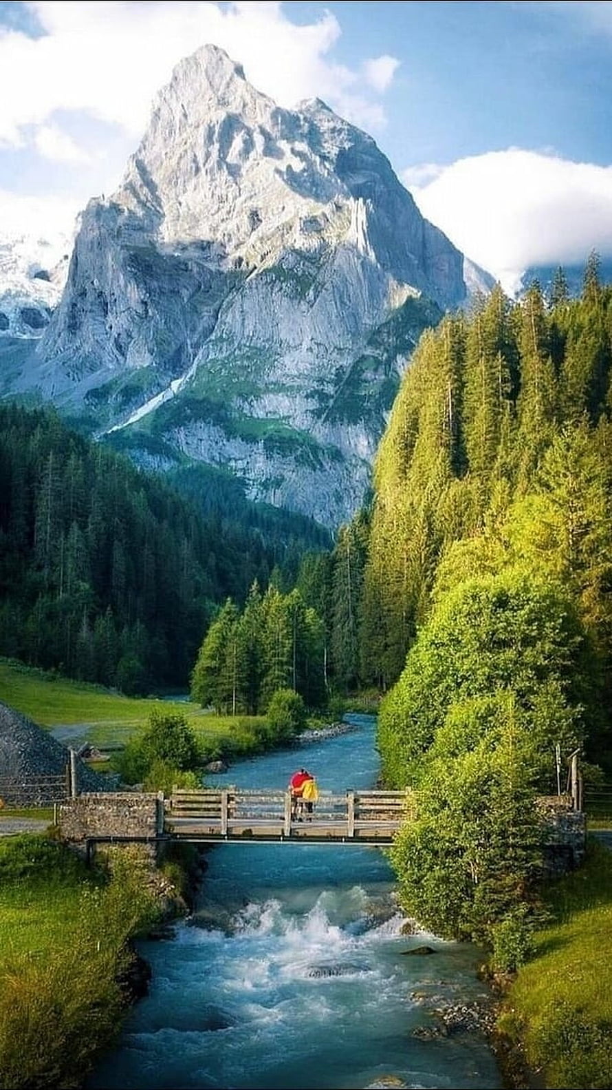 Alpine River Valley with Pedestrian Bridge and Majestic Mountain Peak in Switzerland HD phone wallpaper