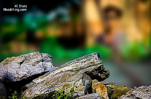 Close-Up of Textured Grey Rocks with Blurred Green Background HD wallpaper