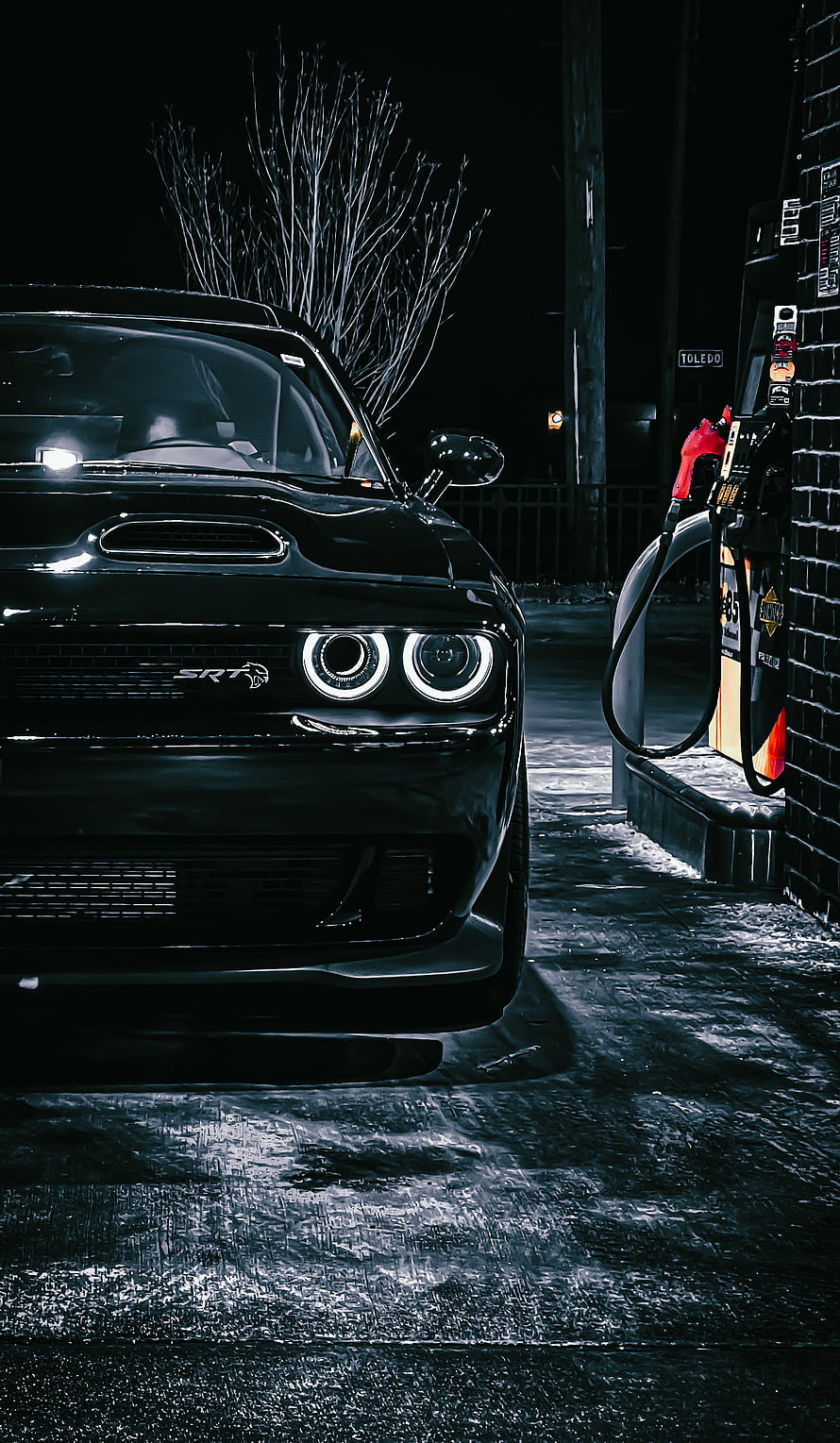 Black Dodge Challenger SRT parked at a gas station at night with glowing headlights HD phone wallpaper