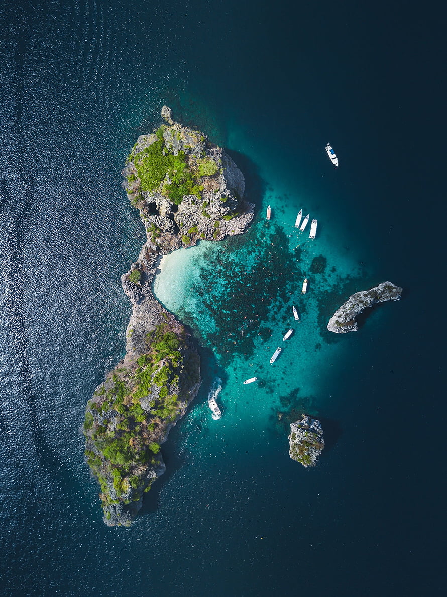 Aerial View of Tropical Island with Turquoise Lagoon and Moored Boats HD phone wallpaper