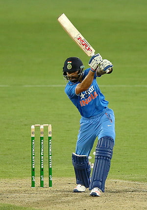 Indian Cricketer Playing a Shot in Blue Jersey on Green Field HD phone wallpaper