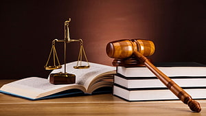 Wooden Gavel and Scales of Justice Resting on Open Law Books HD wallpaper