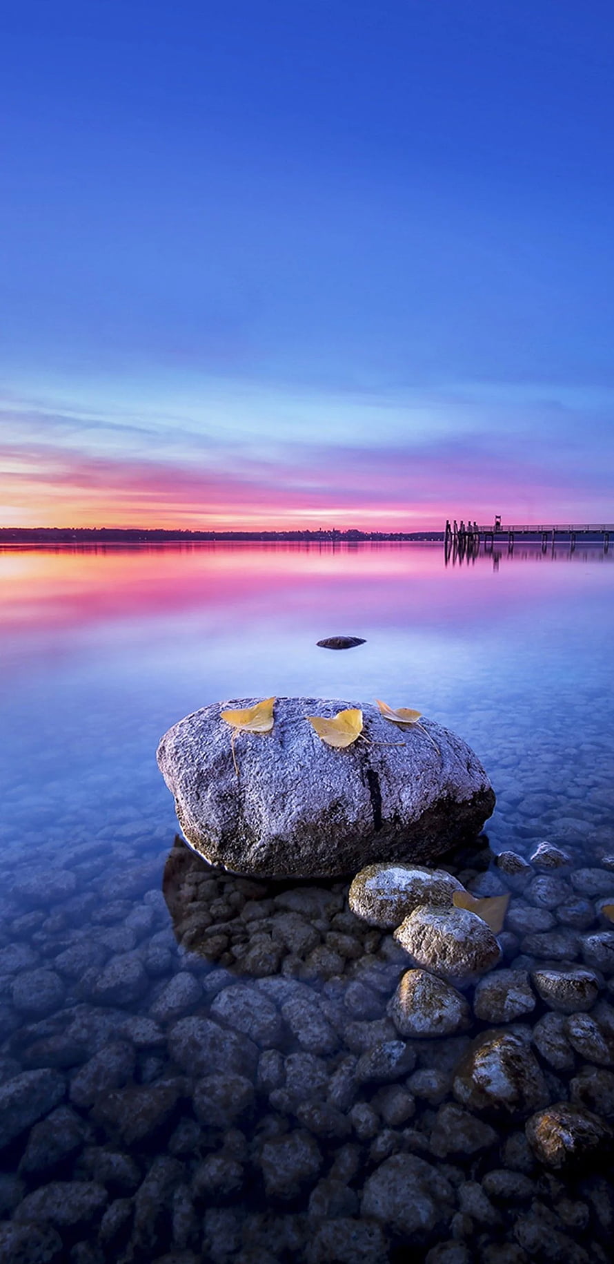 Serene Lake Sunset With Large Rock And Yellow Leaves In Foreground HD phone wallpaper