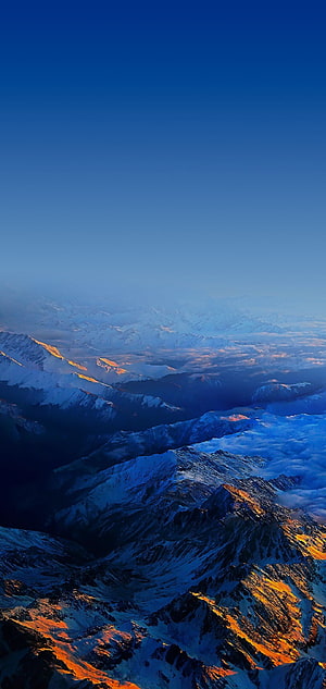 Snow-Capped Mountain Peaks Bathed in Golden Sunrise Light Above Sea of Clouds HD phone wallpaper