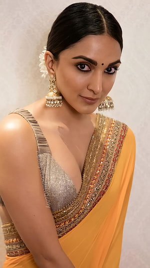 Kiara Advani in a stunning yellow saree with gold jewelry and traditional Indian bridal makeup HD phone wallpaper
