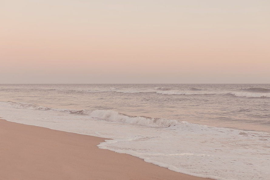 Serene Pink Sunset Beach With Gentle Ocean Waves Rolling Onto Sandy Shore HD wallpaper
