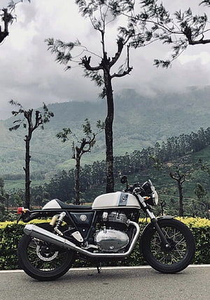 Royal Enfield Classic 350 motorcycle parked on a scenic mountain road with pine trees and misty hills HD phone wallpaper