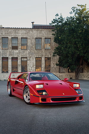 Red Ferrari F40 Super Car Parked in Front of Weathered Industrial Building HD phone wallpaper