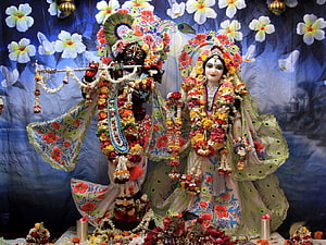 Radha Krishna Deities Adorned in Floral Garlands and Peacock Feathers HD wallpaper